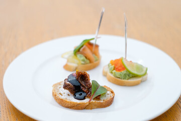 Bruschetta with dried vegetables, fish and caviar.  Decorated catering banquet menu with different food snacks and appetizers with sandwich.