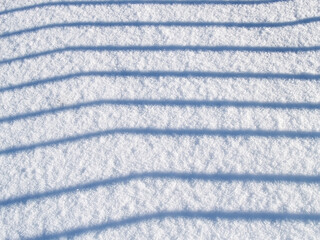 Horizontal bands of shadows on the snow surface. Background