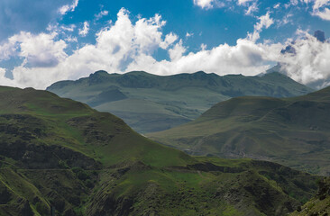 Mountain landscape with blue sky. Panoramic view of green hills.