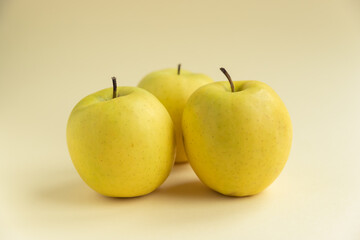 yellow golden delicious apples on yellow background