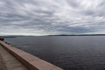 houses on the embankment near a large lake on a gray background