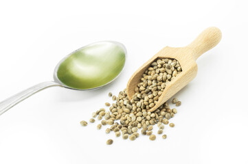 Heap of dried organic hemp seeds or cannabis plant seeds with hemp seed oil  in spoon isolated on white background