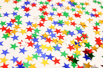 multicolored stars glitter on white background. Festive holiday card