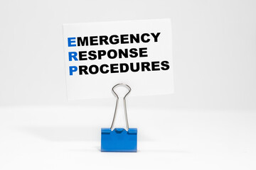 EMERGENCY RESPONSE PROCEDURES nscription on a white business card on a white endless background in a blue clip.