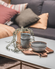 Fototapeta na wymiar Coffee cups and a bowl on a cutting board with a plant simple home decor