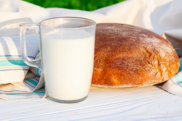 Daylight. rye bread on a white wooden background next to a glass of milk. Copy space