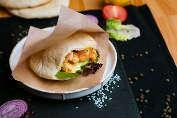 Mexican food. Homemade tacos with shrimp, avocado and salsa sauce on a dark rustic background. Overhead.