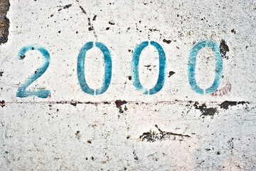 Number two thousand, 2000, blue digits on white painted wall.