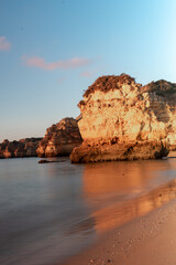 Fototapeta na wymiar Sunrise on the beach. Early morning, calm ocean. Lagos, Algarve Coast, Portugal