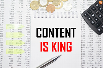 CONTENT IS KING on the block on the background of financial reporting, coins, calculator, pens and yellow stickers. Business concept