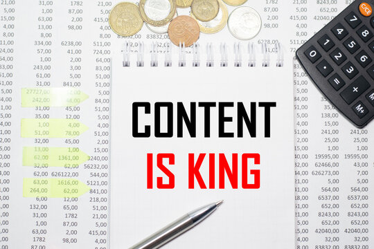 CONTENT IS KING on the block on the background of financial reporting, coins, calculator, pens and yellow stickers. Business concept