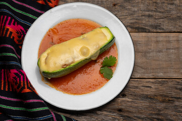 Stuffed zucchini with tuna and melted cheese on wooden background