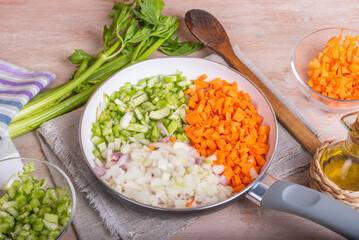 Cooking carrot and celery onion vegetable dressing, chopped ingredients for Mirepoix or Soffritto in a skillet