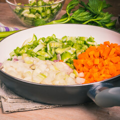 Cooking carrot and celery onion vegetable dressing, chopped ingredients for Mirepoix or Soffritto in a skillet