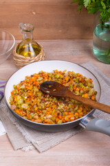 The preparation of fried vegetable filling of onions carrots and celery - ready Mirepoix or Soffritto  in a frying pan.