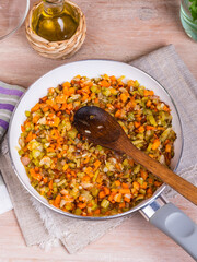 The preparation of fried vegetable filling of onions carrots and celery - ready Mirepoix or Soffritto in a pan, top view.