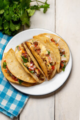 Mexican hard-shell tacos with meat and fresh sauce on white background