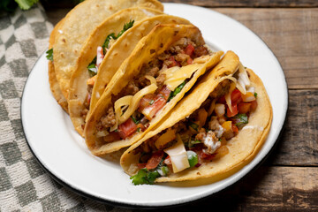 Mexican hard-shell tacos with meat and fresh sauce on wooden background