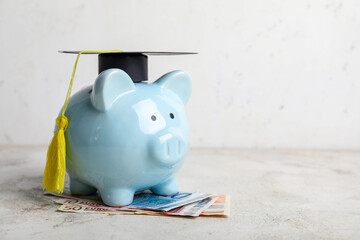 Piggy bank with graduation hat and money on table. Tuition fees concept