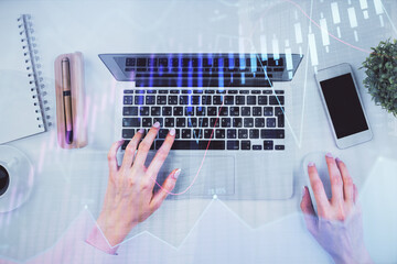 Double exposure of woman hands working on computer and forex chart hologram drawing. Top View. Financial analysis concept.