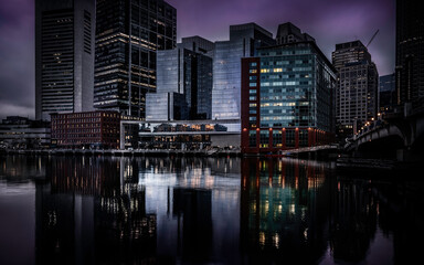 Fototapeta premium Moody Nightscape of Central Boston Financial District and reflections on the Boston Harbor