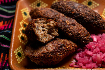 Mexican kibi with meat and onion on rustic background