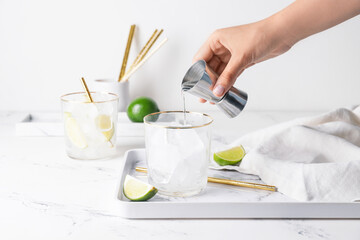 Woman making fresh mojito at table
