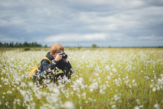 Photographer taking shot among beautiful blooming field