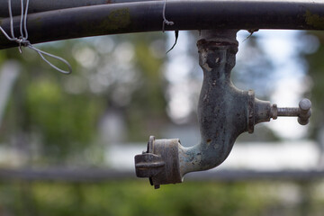 Old upside down water tap for watering plants in a abandoned greenhouse
