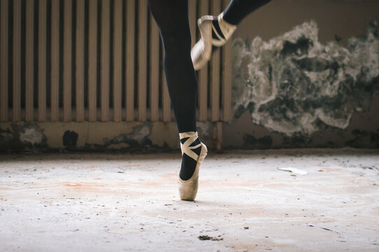 detail of ballet dancer's feet in an urban warehouse setting.