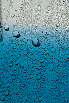 Macro closeup of rain water drops on a windshield looking outward