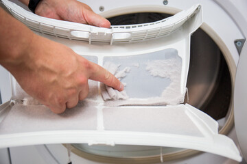 Dryer filter, dirty and needs to be cleaned, clothes dust has gathered in one place