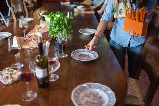 Group of Friends Setting Kitchen Table with Dishware for Meal
