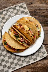 Mexican hard-shell tacos with meat and fresh sauce on wooden background