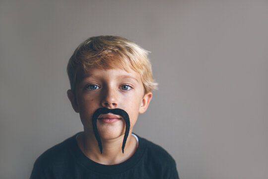 serious kid with a mustache