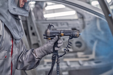 employee body painting workshop carries out painting of the internal elements of the car.