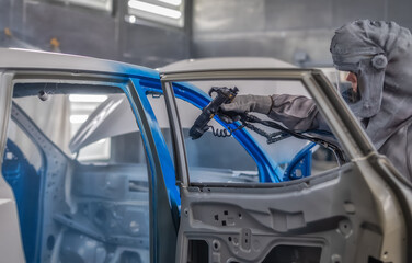 employee body painting workshop carries out painting of the internal elements of the car.