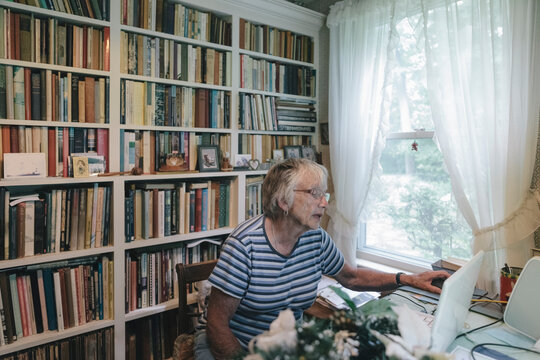 Senior Woman Using Computer and Internet Technology at Home in her Study