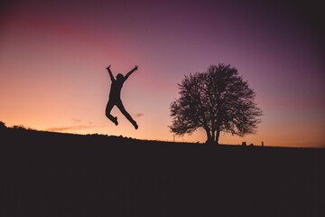 Girl Jumps so high with sunset in the background