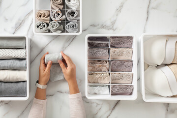 Woman hands placing organizer drawer divider with full of folded underwears and socks.