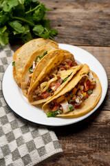 Mexican hard-shell tacos with meat and fresh sauce on wooden background