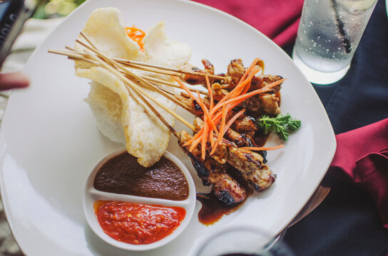 Traditional chicken satay with rice and crackers
