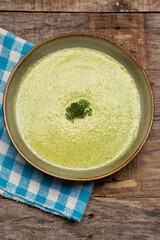 Cream of broccoli soup on wooden background