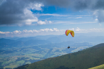Paragliding in the cloudy blue sky.