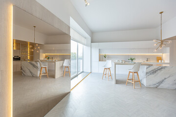 luxury interior design of modern trendy snow white kitchen in minimalistic style with island and two bar stools. huge windows to the floor and a glass rack for dishes