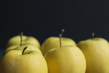 yellow golden delicious apples on a black background
