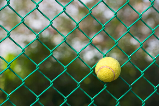 Tennis ball stuck in the perimeter fence