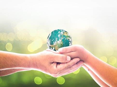 Earth day concept: Human hands holding earth global on blurred nature background. Elements of this image furnished by NASA