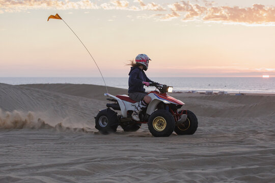 Woman riding a quad while watching a sunset