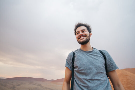 Young happy man with spiky hair because of electrical storm on the desert